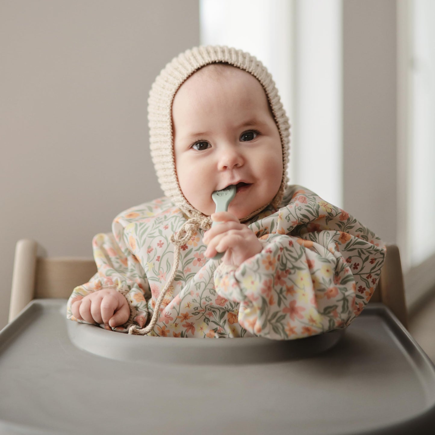 mushie Long Sleeve Baby Bib | Water Resistant Adjustable Fit for Ages 6-24 Months (Pastel Blooms)
