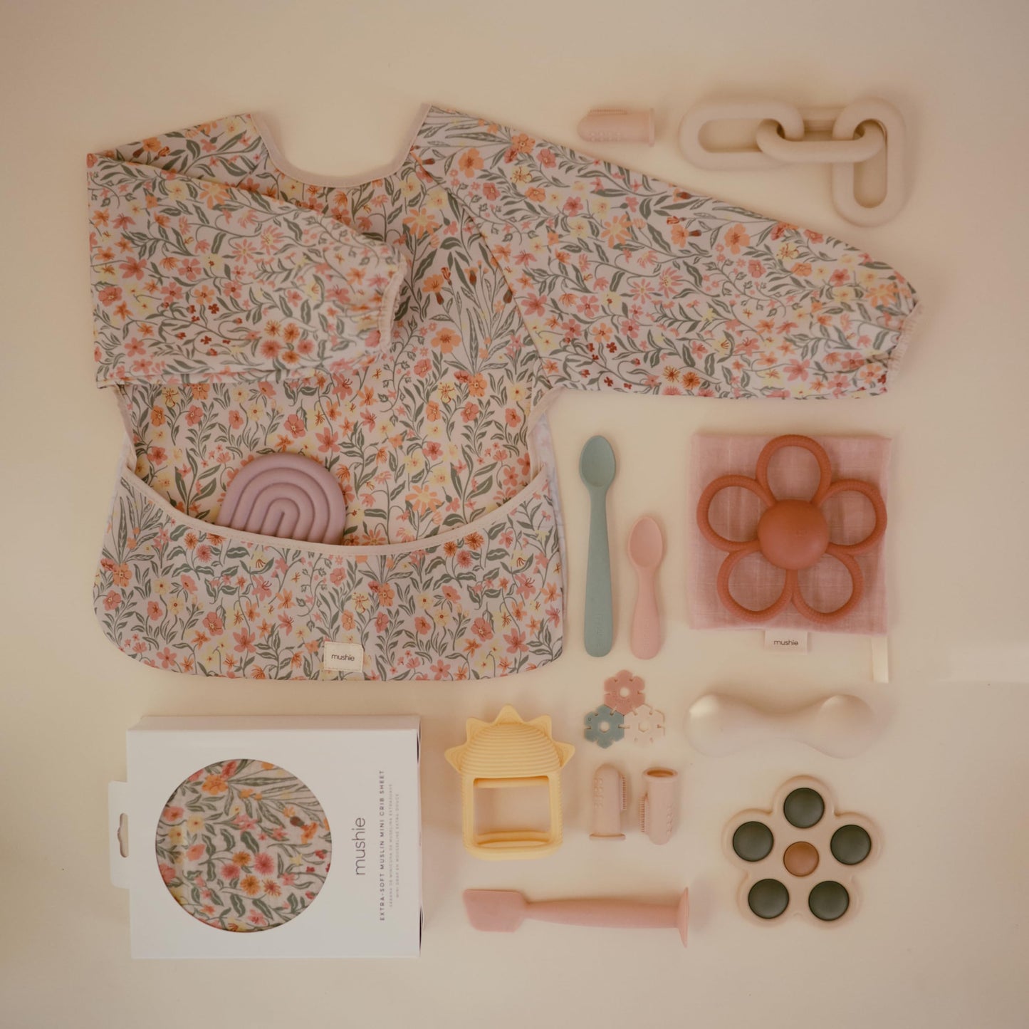 mushie Long Sleeve Baby Bib | Water Resistant Adjustable Fit for Ages 6-24 Months (Pastel Blooms)